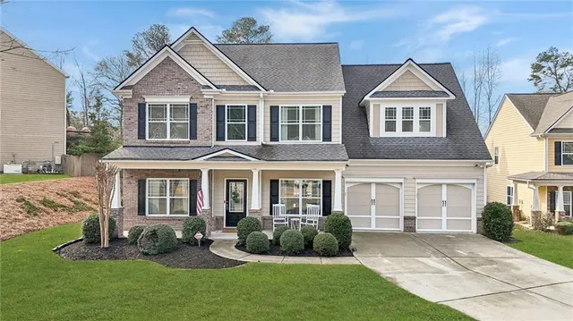 a front view of a house with a yard and porch