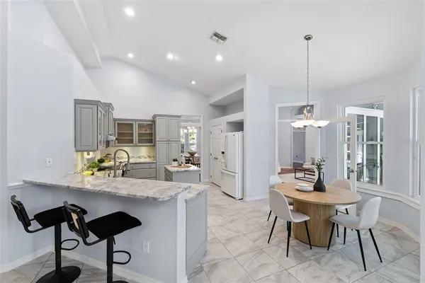 a kitchen with a dining table chairs and sink