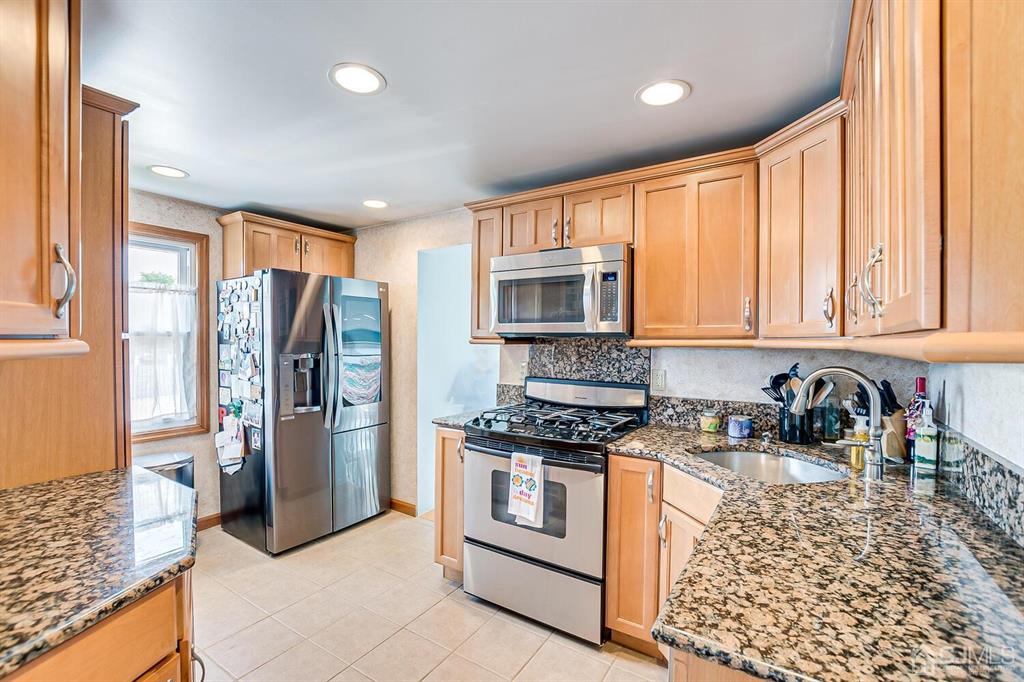 13 Highfield Road Colonia, NJ 07067 - Photo 13 of 42 a kitchen with stainless steel appliances granite countertop a stove a sink and a refrigerator