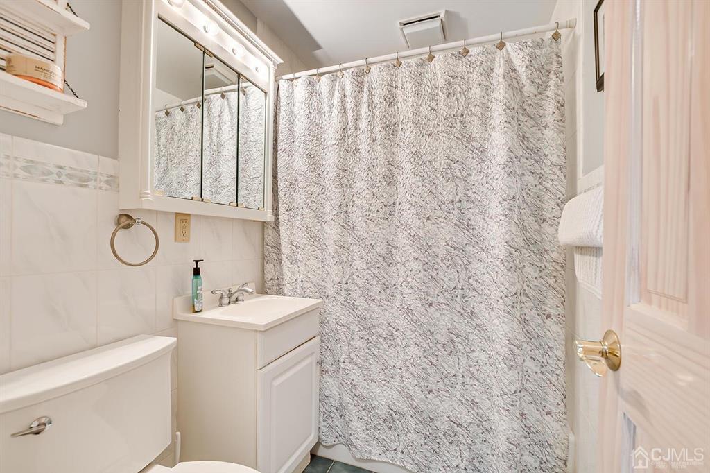 13 Highfield Road Colonia, NJ 07067 - Photo 20 of 42 a bathroom with a sink a toilet and a shower curtain