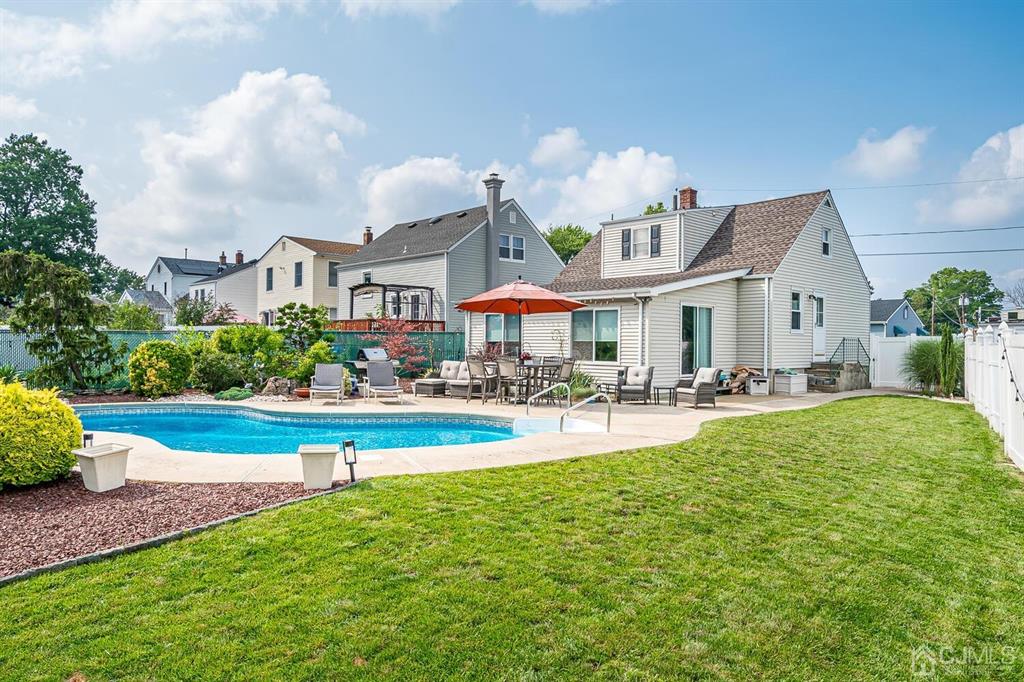 13 Highfield Road Colonia, NJ 07067 - Photo 37 of 42 a front view of house and yard with swimming pool and seating