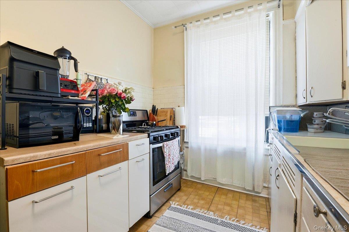 60-58 60th Road Queens, NY 11378 - Photo 16 of 25 a kitchen with stainless steel appliances a stove and a refrigerator