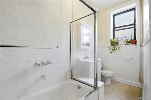 a bathroom with a granite countertop sink a toilet and shower