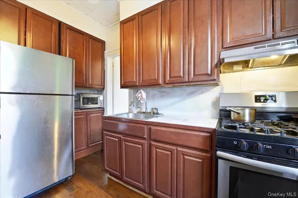 a kitchen with stainless steel appliances granite countertop a refrigerator stove and cabinets