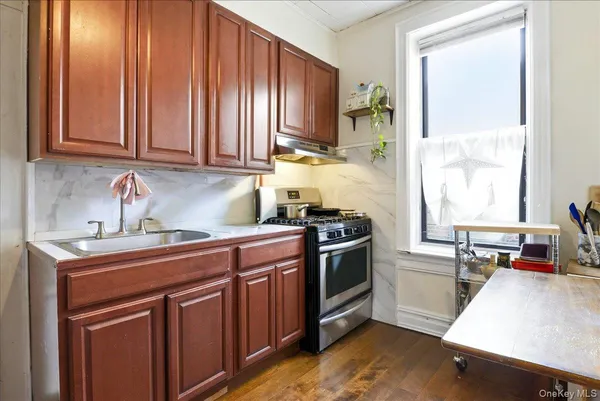 a kitchen with stainless steel appliances granite countertop a sink stove and cabinets