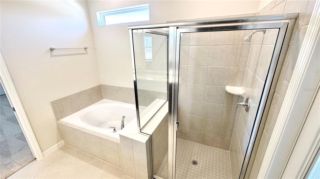 16248 St Kitts Circle Clermont, FL 34714 - Photo 11 of 27 a bathroom with a bathtub and a shower