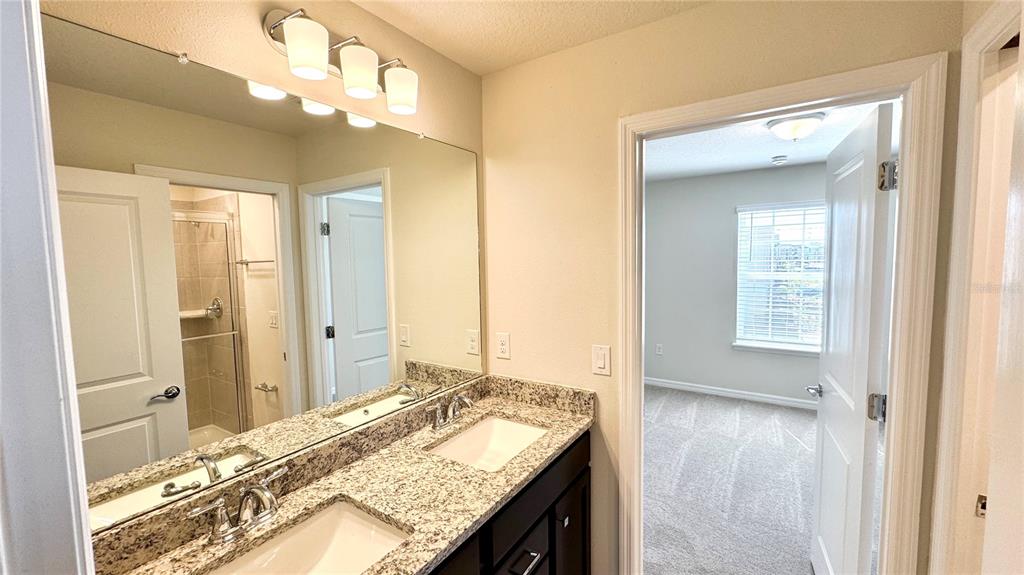 16248 St Kitts Circle Clermont, FL 34714 - Photo 17 of 27 a bathroom with a granite countertop sink and a mirror