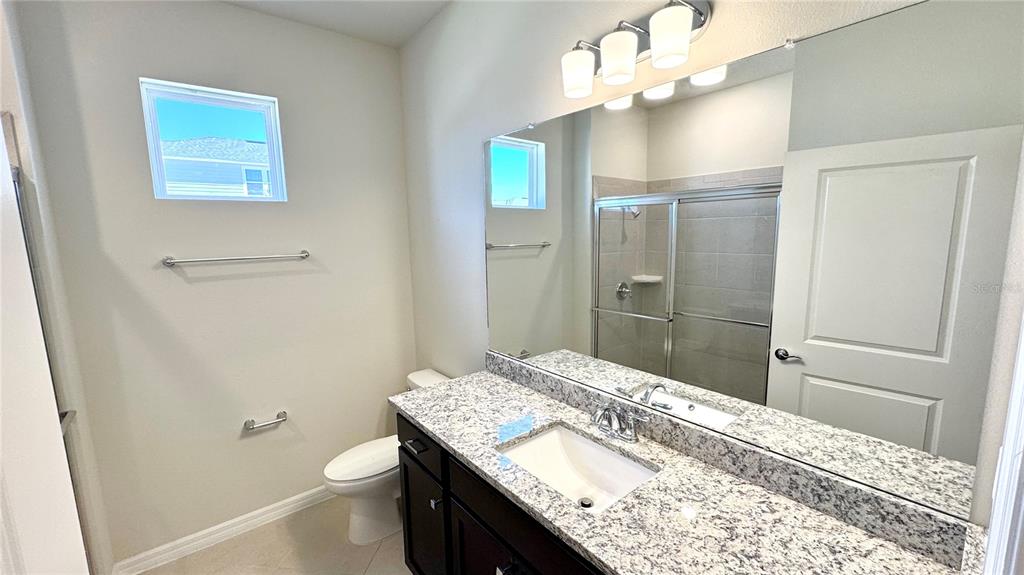 16248 St Kitts Circle Clermont, FL 34714 - Photo 8 of 27 a bathroom with a granite countertop sink a toilet and shower