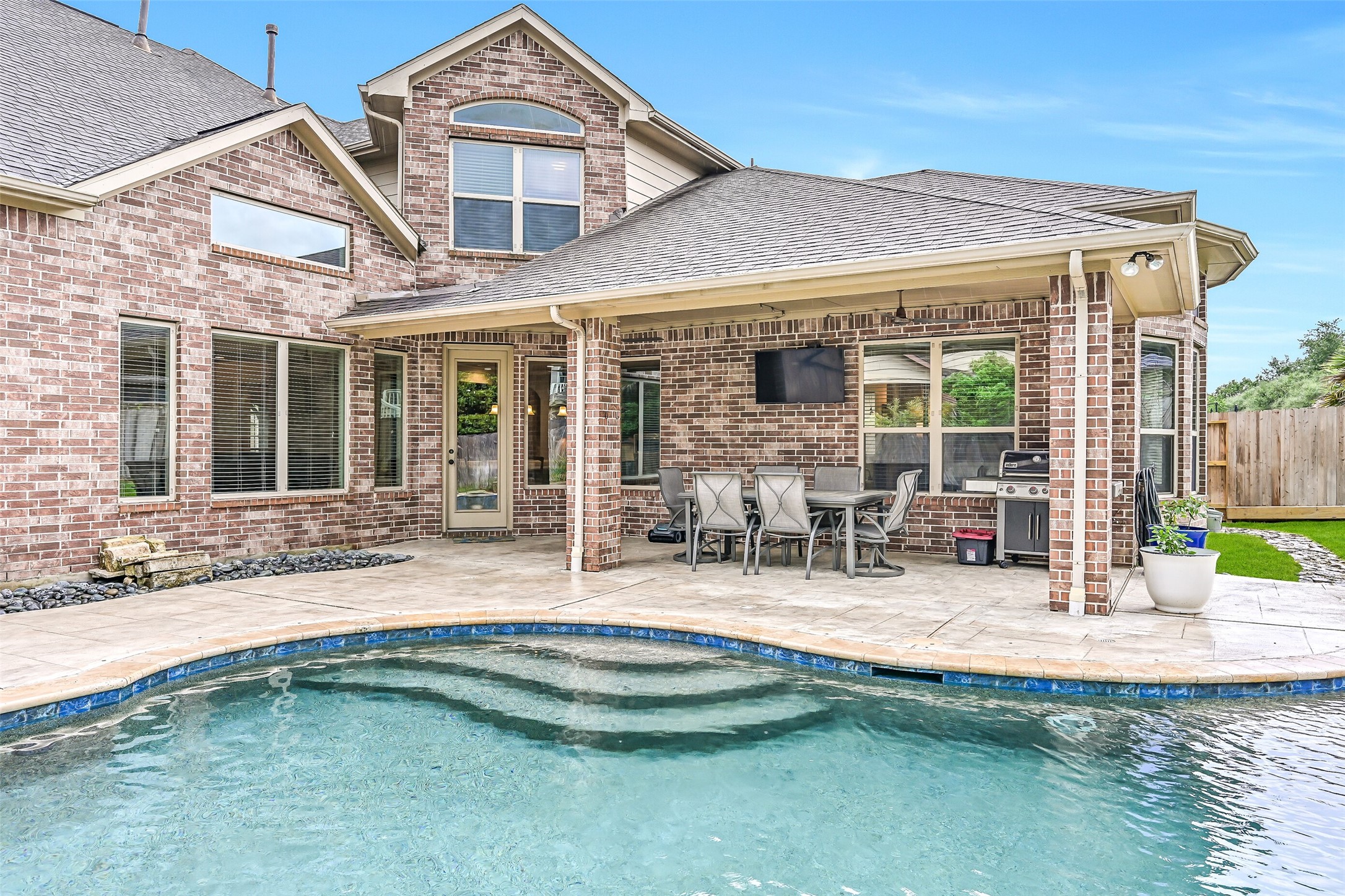 1008 Point Isabel Lane Friendswood, TX 77546 - Photo 46 of 50 This private backyard features a sparkling pool, raised spa, and clean landscaping design. The fully fenced yard adds privacy while still allowing space for play and outdoor enjoyment.