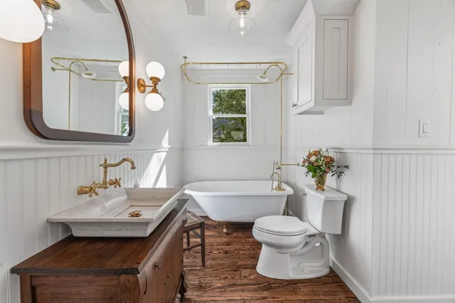 a bathroom with a sink toilet a mirror and tub