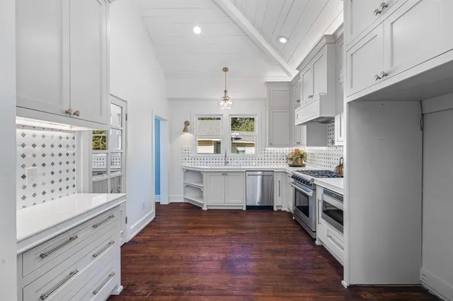 a large kitchen with stainless steel appliances and white cabinets