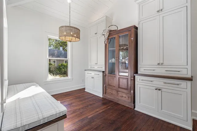 a kitchen with stainless steel appliances granite countertop a refrigerator a oven and white cabinets with wooden floors