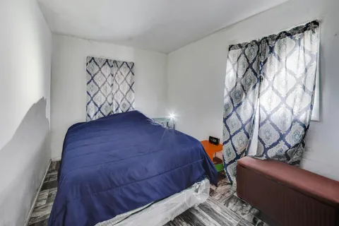 a bedroom with a bed and a wooden floor