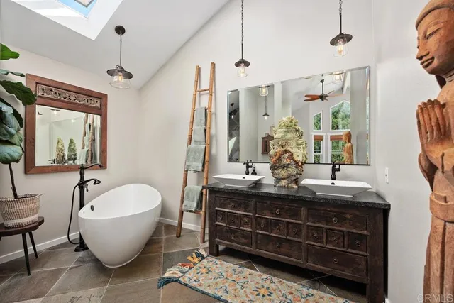 a bathroom with a double vanity sink a mirror and a bathtub