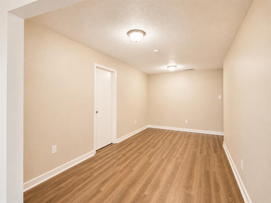 1231 Rutherford Drive Mesquite, TX 75149 - Photo 24 of 29 an empty room with wooden floor and windows
