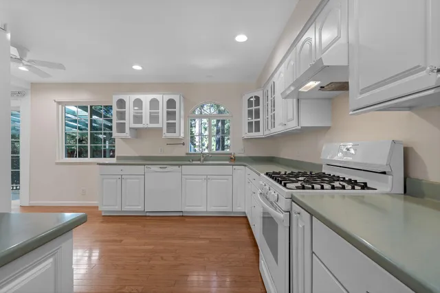a kitchen with stainless steel appliances granite countertop a stove a sink and a wooden cabinets