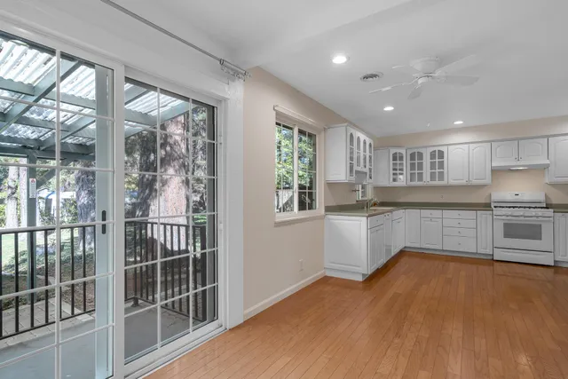 a kitchen with stainless steel appliances wooden floors and white cabinets