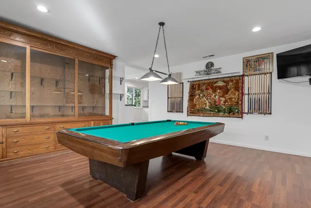 a room with pool table and windows