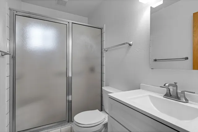 a bathroom with a sink a toilet and shower