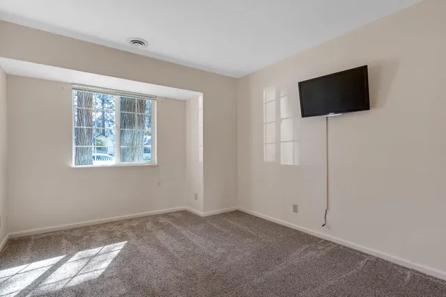 a view of a livingroom with wooden floor and a flat screen tv