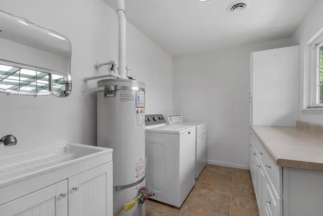 a utility room with sink dryer and washer