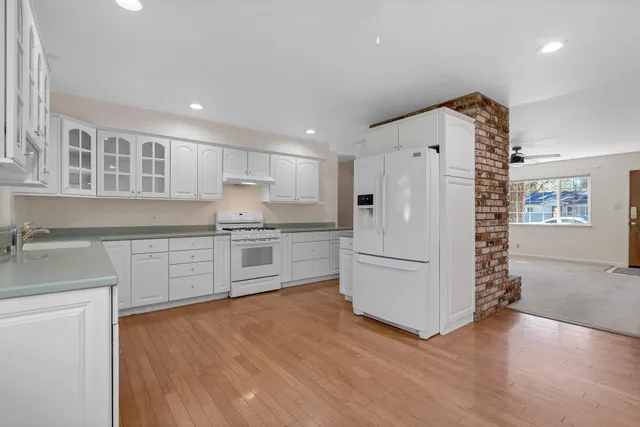 a kitchen with white cabinets and white appliances