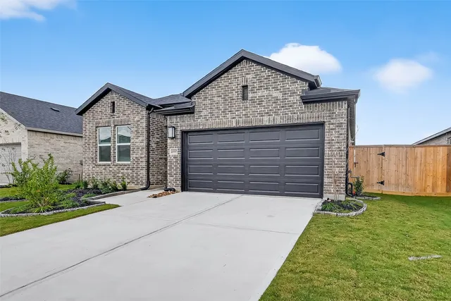 a front view of a house with a garden and plants