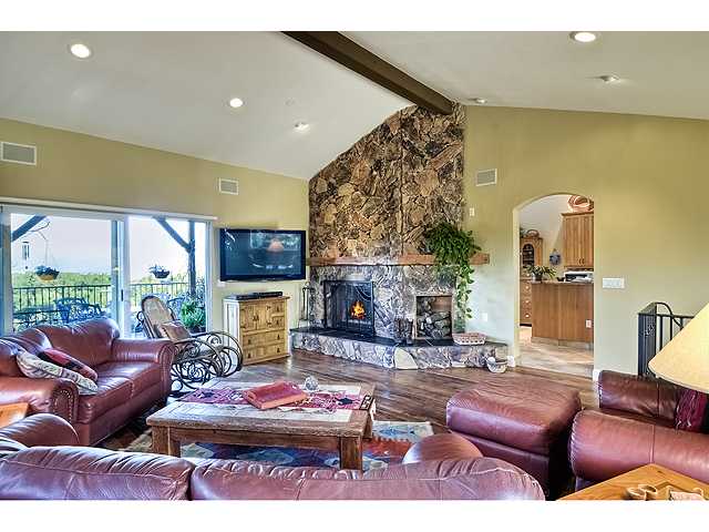 16591 Highland Valley Road Ramona, CA 92065 - Photo 6 of 25 Different angle in family room with views into kitchen...FANTASTIC stone wood burning fireplace! Now, this is what a fireplace should be!