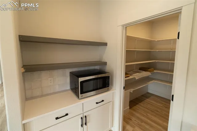 an empty room with windows and ceiling fan