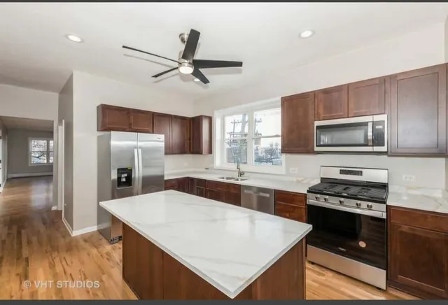 a kitchen with stainless steel appliances a stove sink microwave and refrigerator