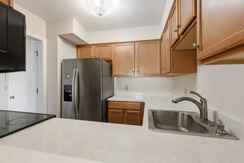 a kitchen with stainless steel appliances granite countertop a refrigerator and a sink
