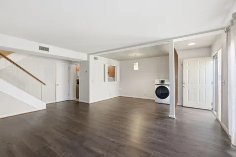 an empty room with wooden floor and mirrors
