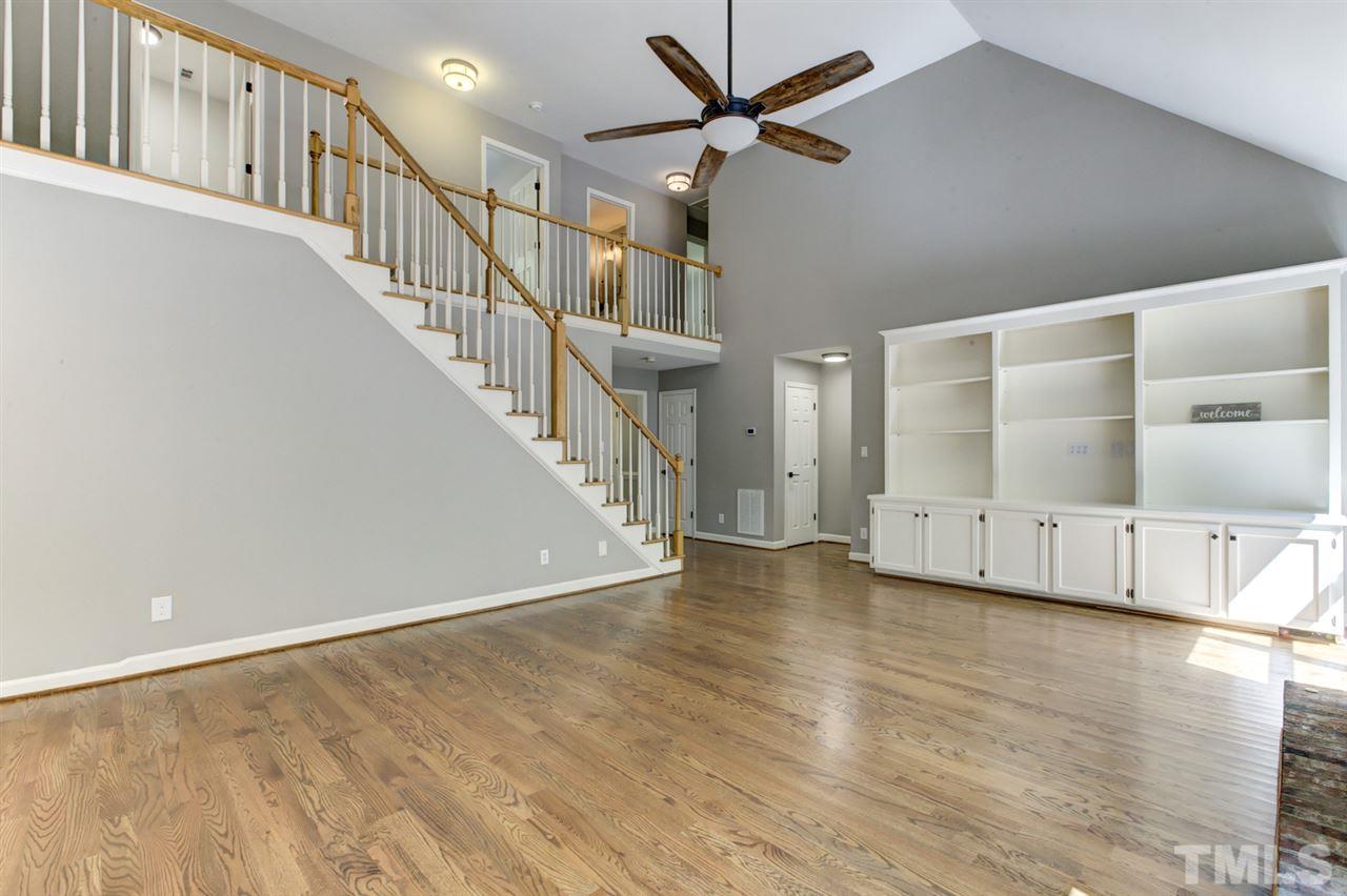 8228 Ridgeback Road Apex, NC 27523 - Photo 12 of 30 a view of a livingroom with wooden floor and a ceiling fan