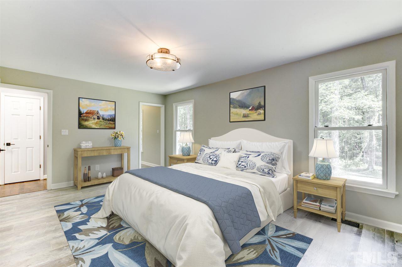 8228 Ridgeback Road Apex, NC 27523 - Photo 13 of 30 a bedroom with a bed and wooden floor