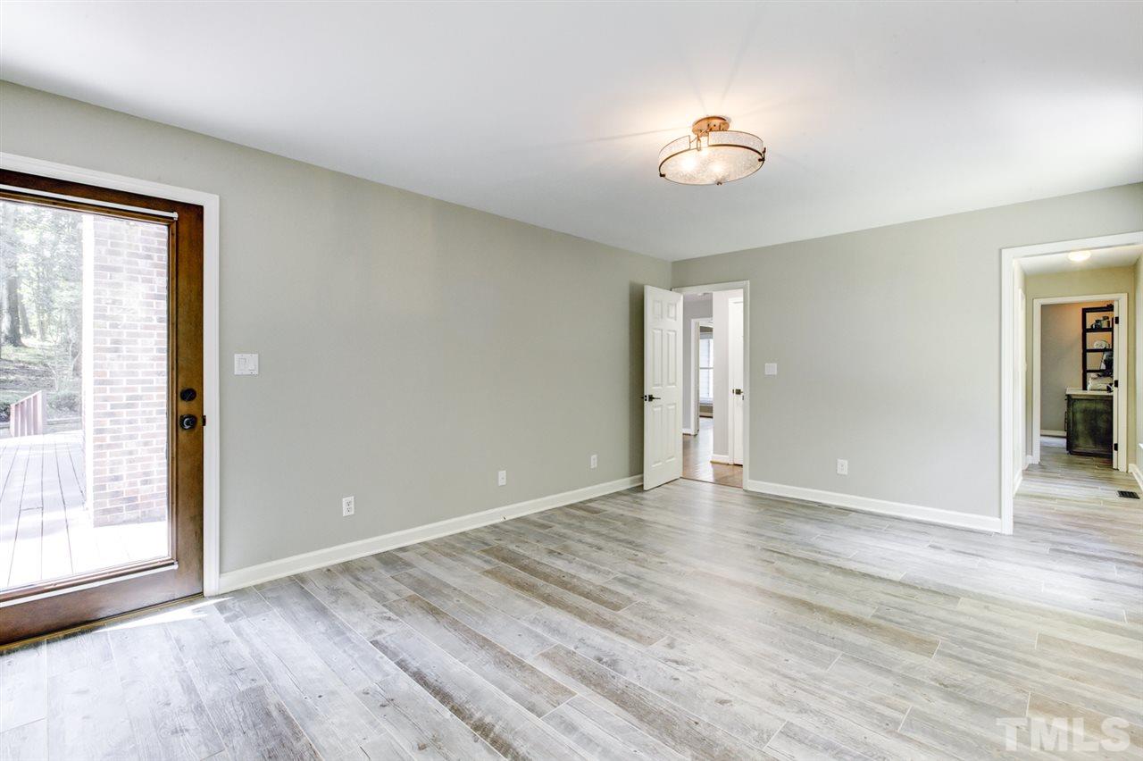 8228 Ridgeback Road Apex, NC 27523 - Photo 14 of 30 a view of an empty room with wooden floor and a window