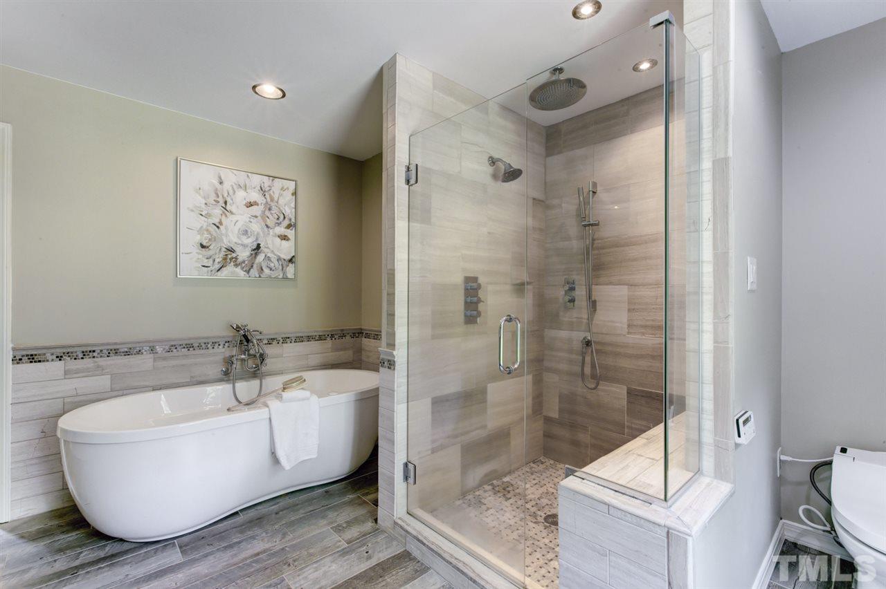 8228 Ridgeback Road Apex, NC 27523 - Photo 18 of 30 a bathroom with a bathtub and a shower