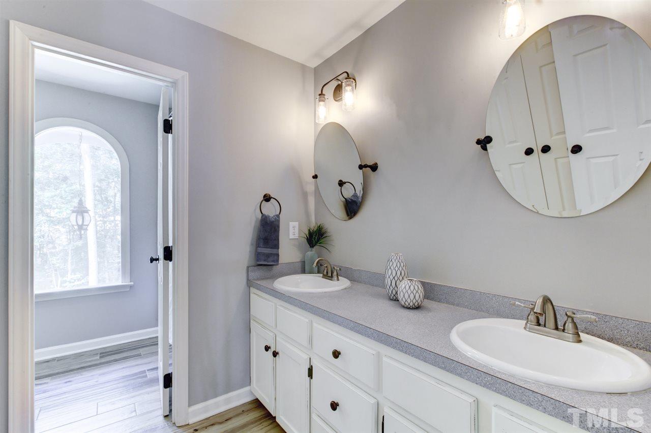8228 Ridgeback Road Apex, NC 27523 - Photo 21 of 30 a bathroom with a double vanity sink and a mirror
