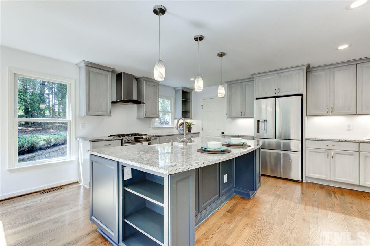 8228 Ridgeback Road Apex, NC 27523 - Photo 5 of 30 a kitchen with kitchen island a sink stove and refrigerator