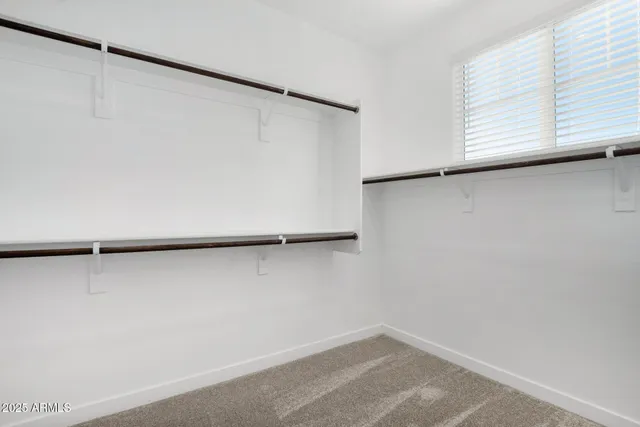 a view of walk in closet with empty racks