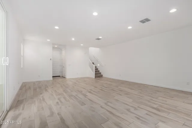 a view of empty room with wooden floor
