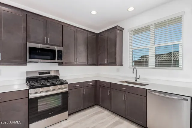 a kitchen with granite countertop a sink stainless steel appliances and cabinets