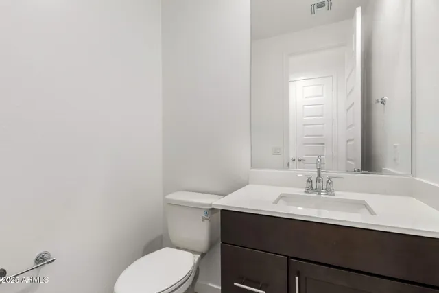 a bathroom with a sink mirror and toilet