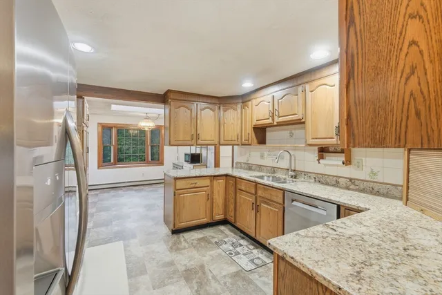 a kitchen with granite countertop sink window and cabinets