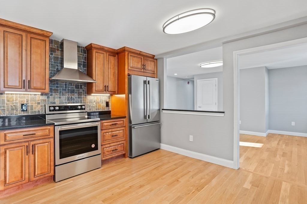 a kitchen with stainless steel appliances granite countertop a refrigerator a stove and a sink