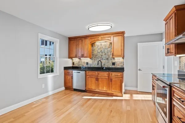a kitchen with stainless steel appliances granite countertop a stove a sink and a refrigerator