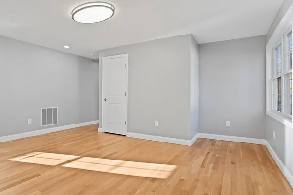 a view of a room with wooden floor and white walls