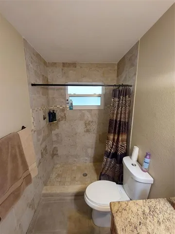 a white toilet sitting next to a bath tub shower