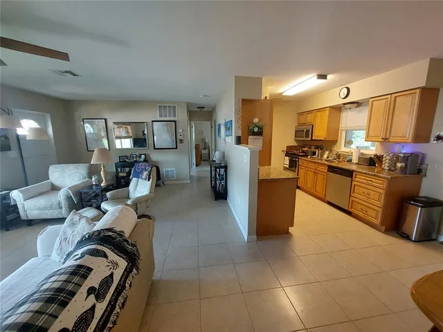 a living room with couches and kitchen view