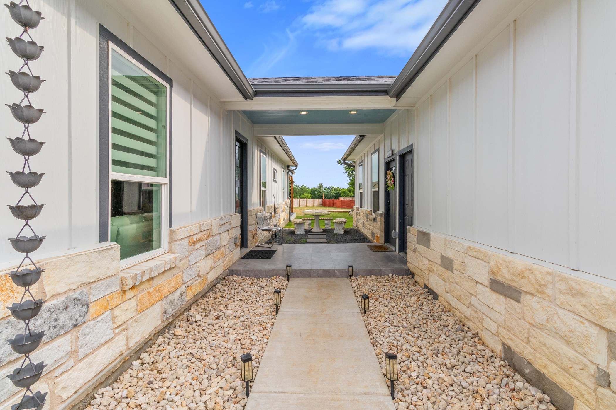 123 Zacate Street Elgin, TX 78621 - Photo 6 of 33 Exterior walkway featuring a concrete path, decorative gravel, and solar pathway lights