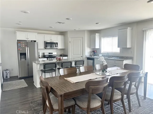 a view of kitchen with refrigerator dining table and chairs